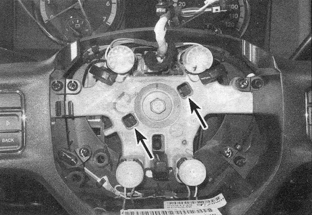 RAM Trucks The steering wheel bolt should be replaced with a new one whenever it's removed; insert the hooks of the steering wheel puller into these holes, with the hooks facing toward the hub