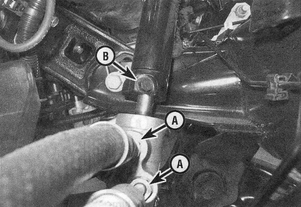 RAM Trucks Remove the pinch bolt from the lower end of the intermediate shaft coupler (B), then unscrew the pressure and return line fittings from the power steering gear (A)