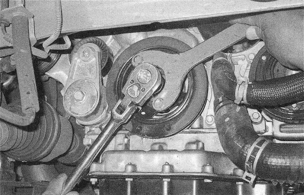 RAM Trucks 3.6L V6 engine Using a special holding tool to prevent the crankshaft from turning, loosen, then remove the bolt