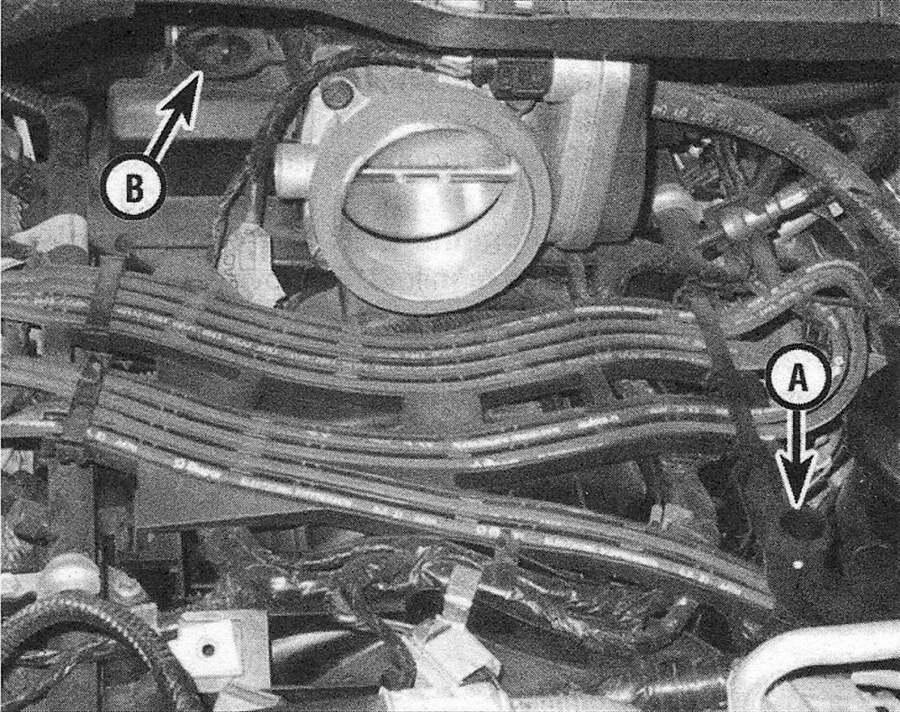 RAM Trucks On Hemi engines, the PCV system consists of a fresh air inlet hose (A) that connects the air resonator box (removed here) to the oil filler tube and the PCV valve (B), which is on the intake manifold to the right of the throttle body