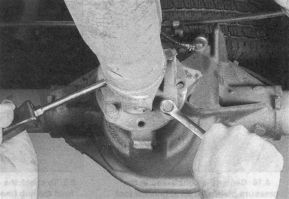 RAM Trucks Clutch and driveline Insert a large screwdriver or prybar through the driveshaft or pinion yoke as shown, to prevent the shaft from turning when you loosen the fasteners